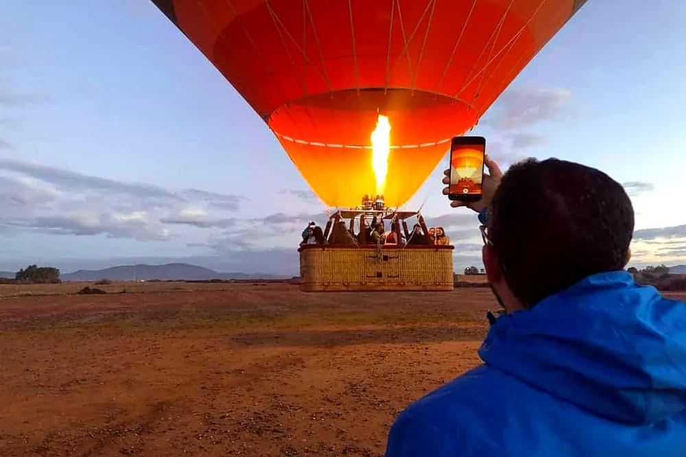 Sunrise balloon flight over palm groves and the Atlas Mountains