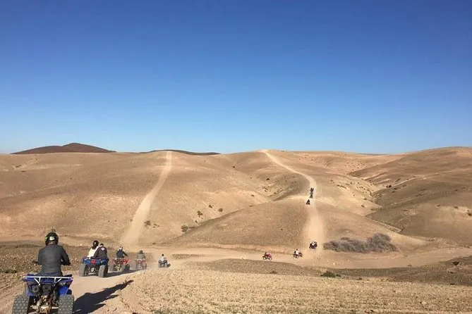 Dust trail behind a quad bike crossing the Agafay desert